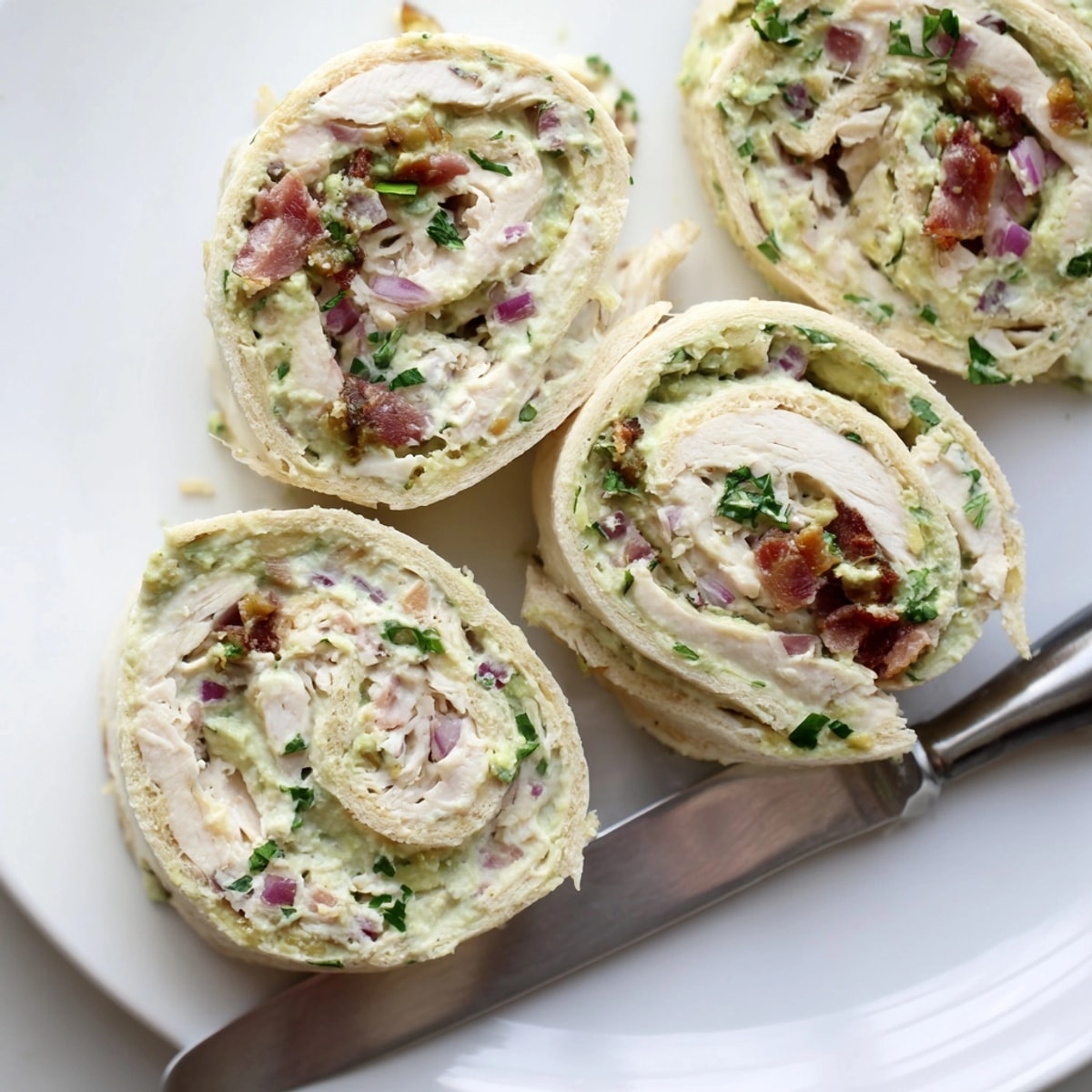 Close-up of creamy Avocado Chicken Bacon Pinwheels, a colorful, irresistible appetizer recipe.