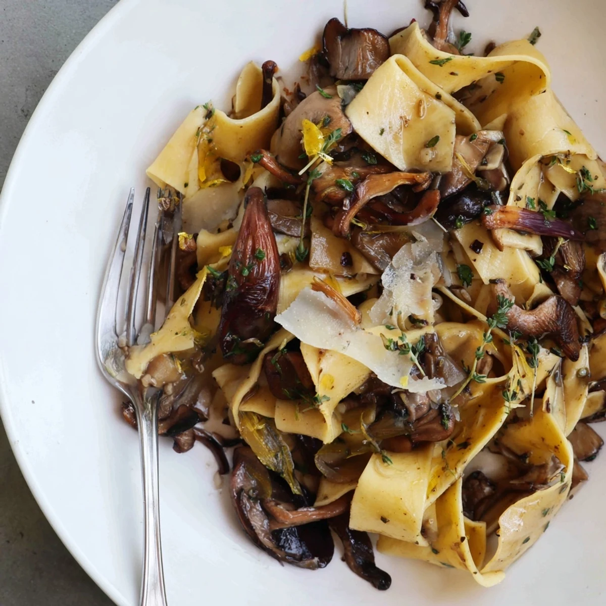 Aromatic fall pasta with wild mushrooms and brown butter, garnished with fresh herbs.  