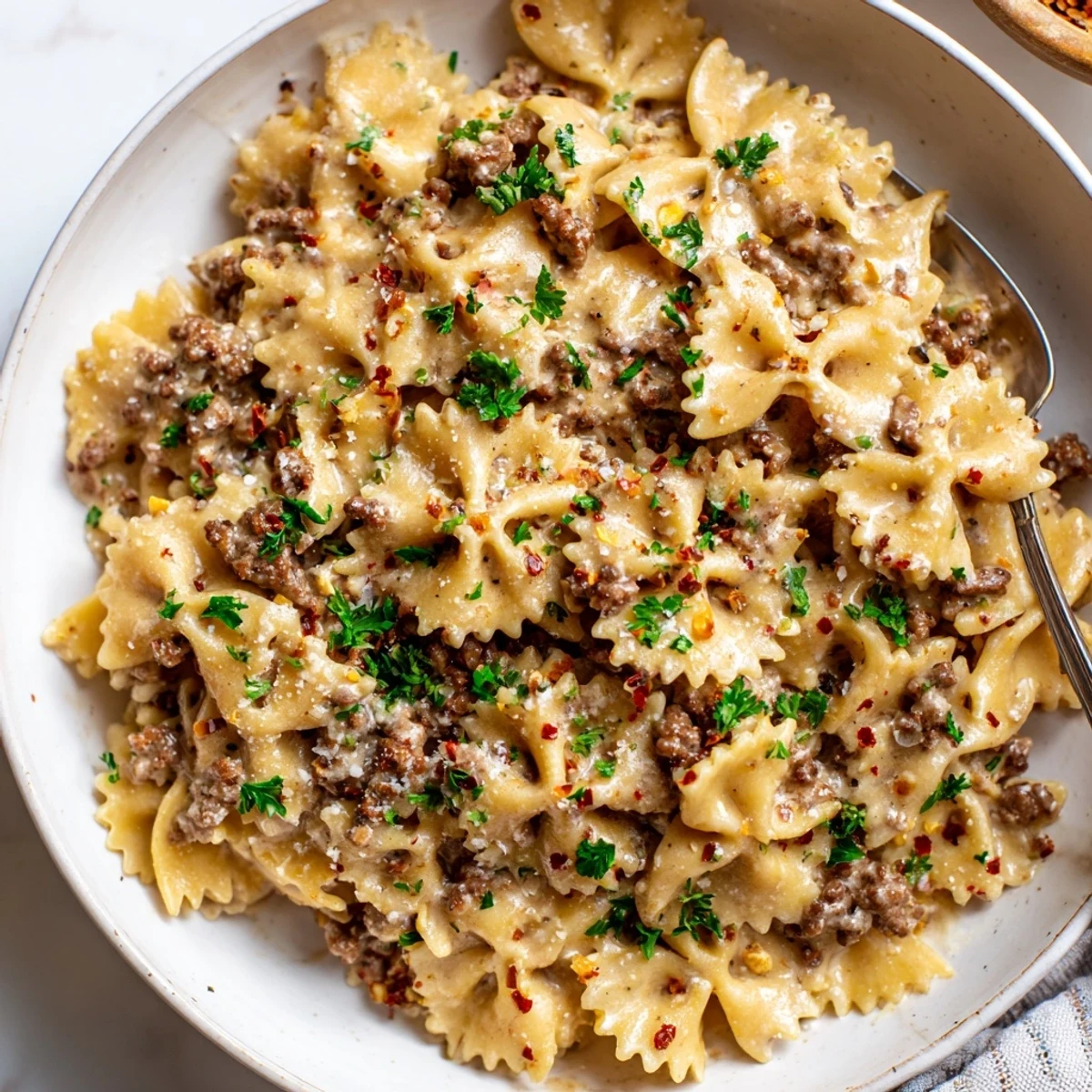 Delicious Beef and Bowtie Pasta with Alfredo Sauce garnished with fresh parsley and red pepper flakes.