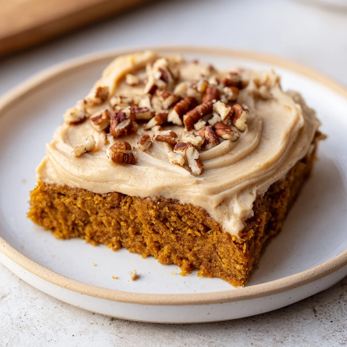 Warm, frosted Pumpkin Bars with a dusting of nuts, ready for slicing and enjoying.