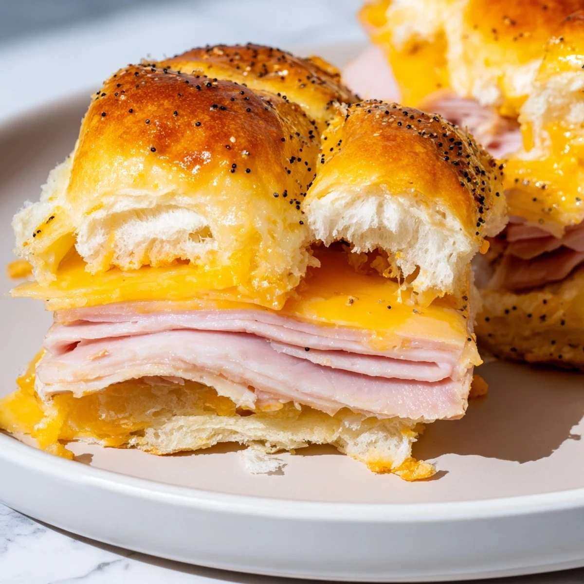 Golden-topped Budget-Friendly Ham & Cheese Sliders, hot from the oven with bubbly, melted cheese and savory ham.