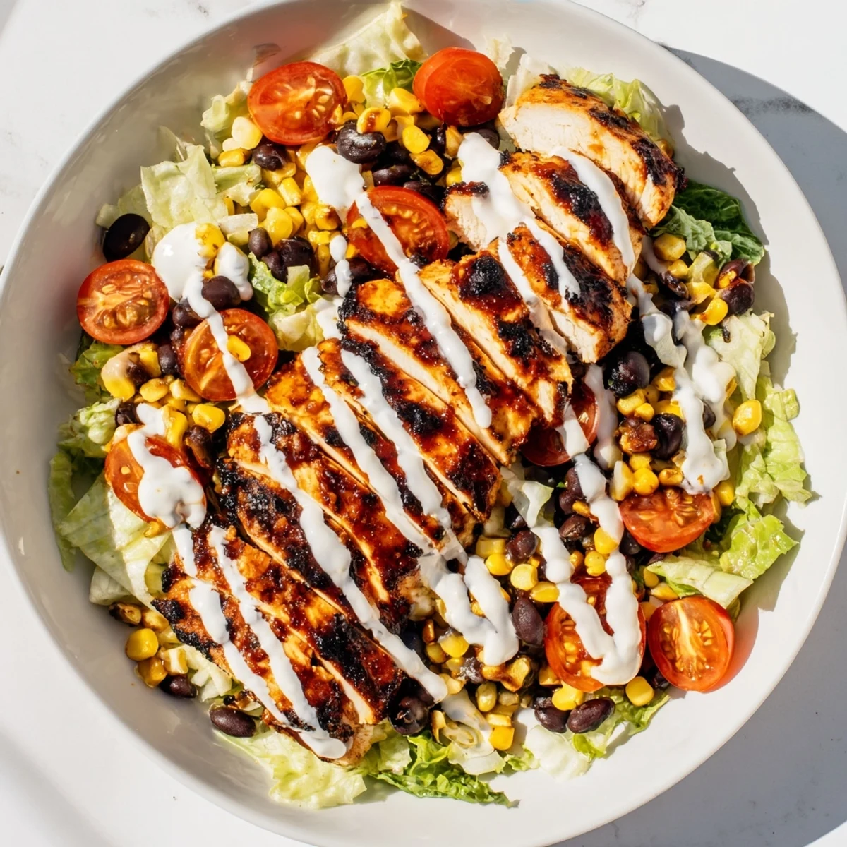Vibrant BBQ Chicken Salad features charred chicken, fresh veggies, and a tangy ranch drizzle, served in a rustic bowl.  