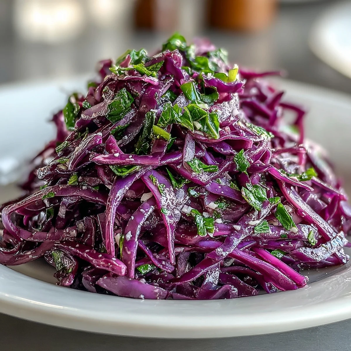 Freshly shredded Red Cabbage Coleslaw With Apple and Parmesan in a white bowl, tossed with tangy vinaigrette and ready to serve as a vegetarian side.