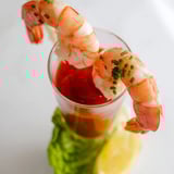 Bright appetizer shot: Retro Prawn Cocktail Shooters, with fresh parsley garnish, ready to eat and enjoy.