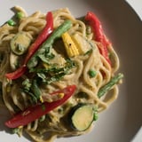 This vibrant photo showcases the rich, aromatic Thai Curry Pasta with fresh cilantro and lime garnishes.