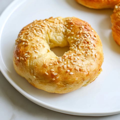 Freshly baked Homemade Budget Bagels, golden-brown and lightly speckled with sesame seeds, ready to eat.