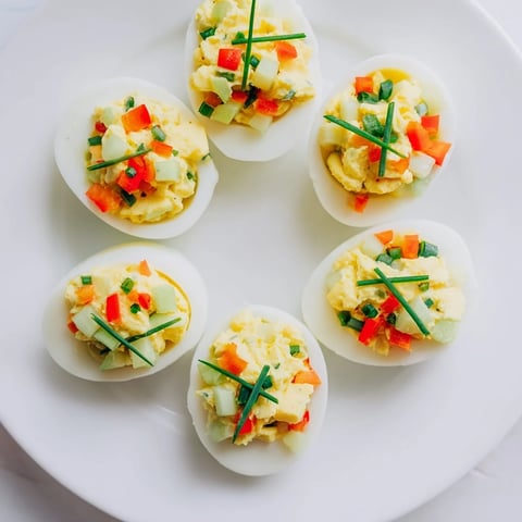 Festive deviled egg ornaments, bright red and green peppers, a delightful holiday appetizer everyone loves.