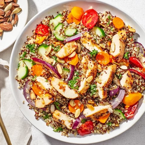 A colorful bowl of Crunchy Quinoa Chicken Salad, showcasing juicy chicken and fresh vegetables.