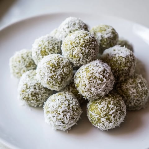 Creamy white Coconut Matcha Snowball Fat Bombs rolled in coconut, a keto-friendly dessert.