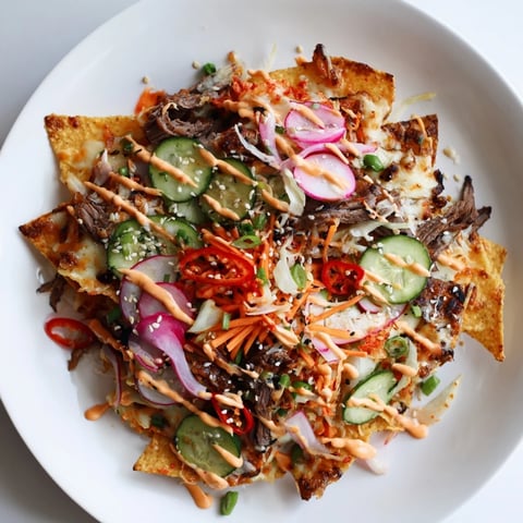 Close-up view of Korean BBQ nachos with melted cheese and savory marinated beef.