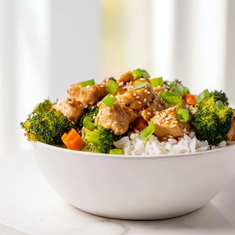 A serving of One Pan Honey Garlic Chicken Broccoli Rice features tender chicken pieces, fluffy grains, and bright green broccoli florets on a plate.