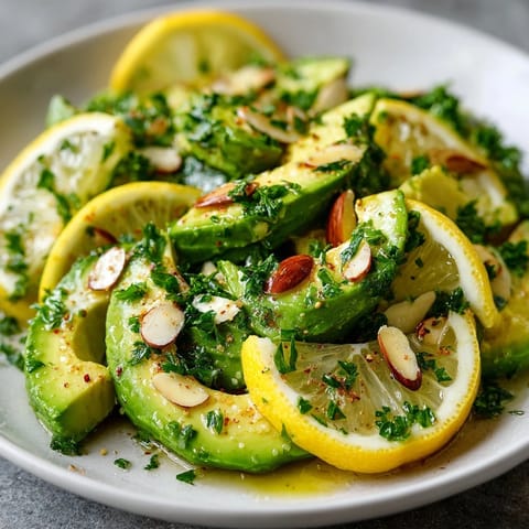 Creamy, refreshing Lemon Avocado Salad recipe, topped with crunchy toasted almonds, served in bowls.