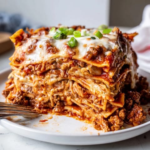 Delicious Spicy Ramen Lasagna, featuring colorful layers and a melty cheese topping.  