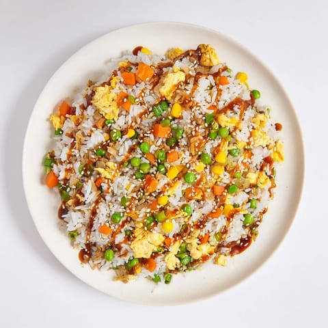Vibrant photo of a wok filled with sizzling Frozen Veggie Fried Rice, savory with egg, ready to eat.