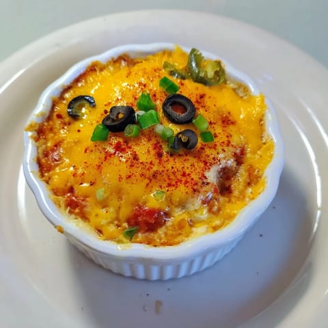 A colorful lava flow volcano dip platter with warm sausage, fresh veggies, and crunchy chips ready to enjoy.