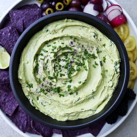 Halloween Witch's Brew cauldron appetizer, a vibrant green dip bubbling with fresh, dark ingredients for dipping.