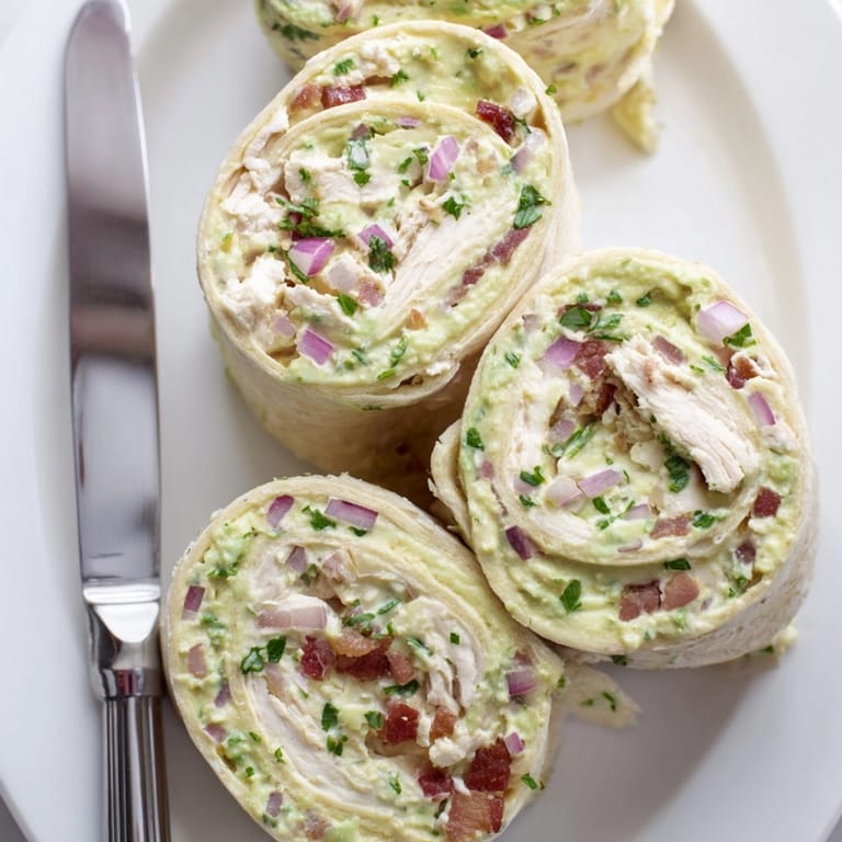 Golden, savory bites: Chilled Avocado Chicken Bacon Pinwheels recipe sliced, ready to serve.