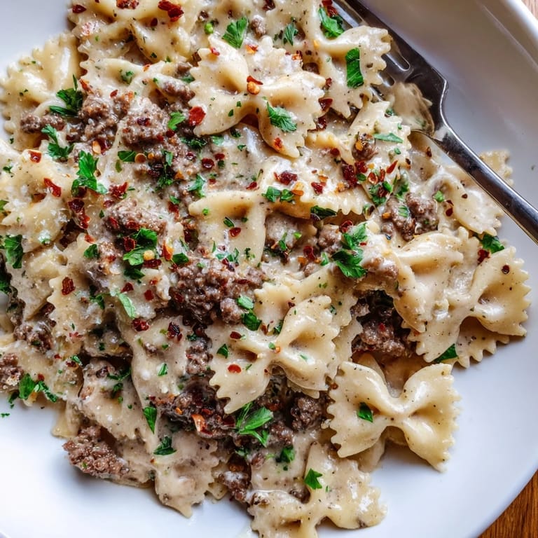 Comforting Beef and Bowtie Pasta coated in rich Alfredo sauce, perfect for family dinners.