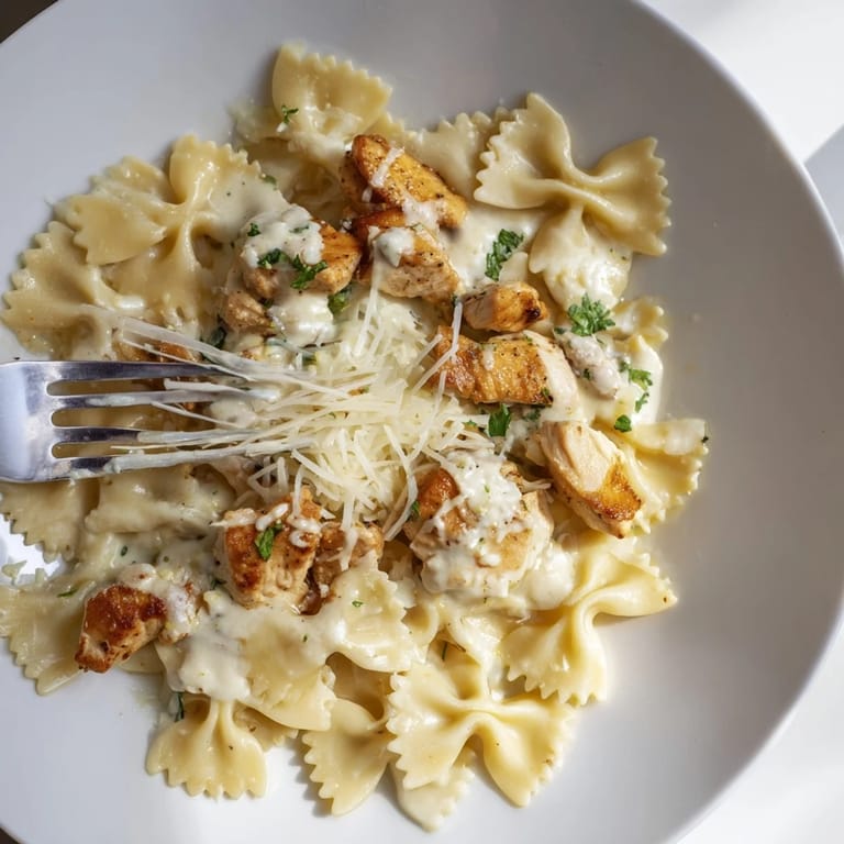 Creamy garlic butter sauce envelops tender chicken and bowtie pasta in this comforting dish.  