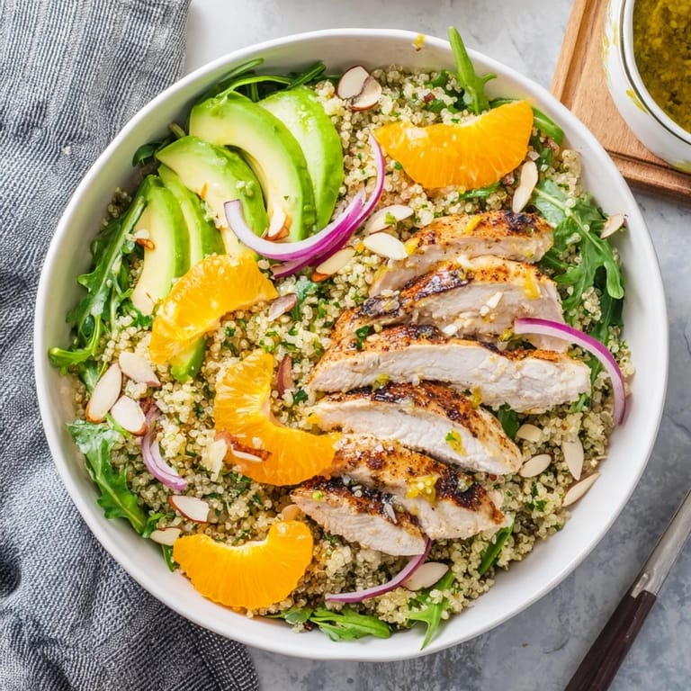 Juicy orange segments and creamy avocado add color to this gluten-free citrus herb chicken salad bowl, drizzled with zesty vinaigrette.