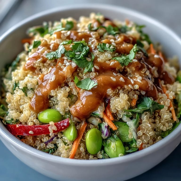 Overhead view of a fresh Thai Coconut Quinoa Bowl, garnished with cilantro and colorful slaw.
