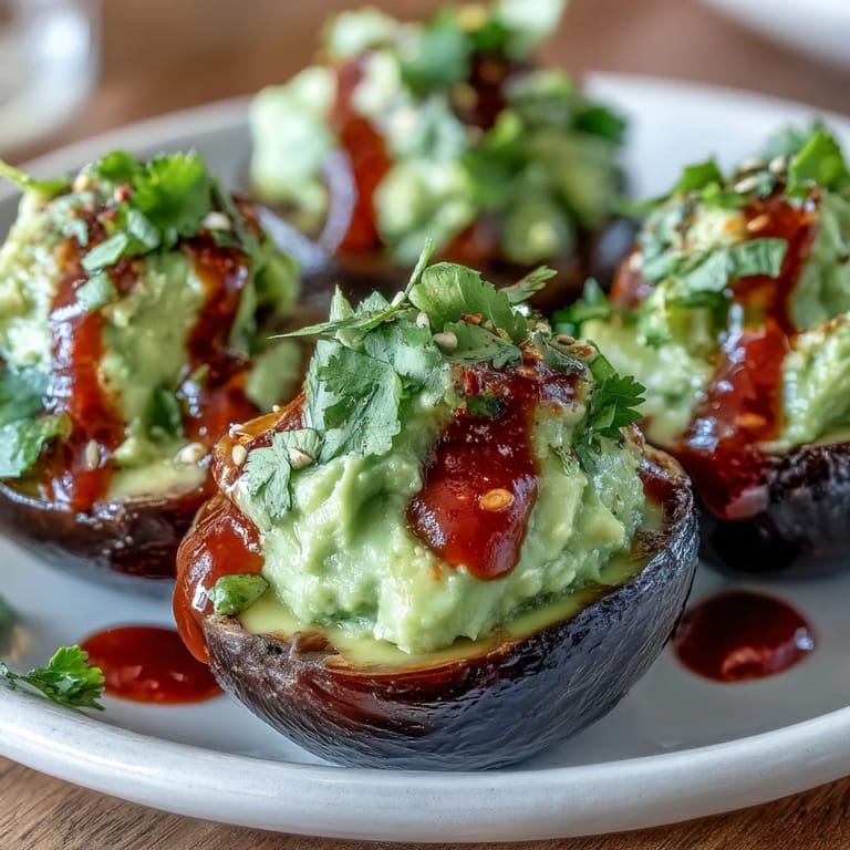 Vibrant green avocado filling in classic deviled eggs, finished with a fiery Sriracha kick and a dusting of paprika.  