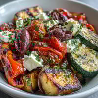 Warm Roasted Greek Salad with vibrant colors, tender vegetables, and creamy feta.