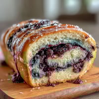 Vibrant lemon blueberry sourdough swirl bread with golden crust and juicy berry ribbons, perfect for breakfast or afternoon tea.  