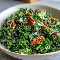 Fresh arugula salad with lemon vinaigrette, topped with shaved Parmesan and toasted pine nuts for a tangy, crunchy bite.