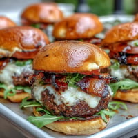 Juicy Father's Day grilled bacon burger sliders piled high with melted cheese.